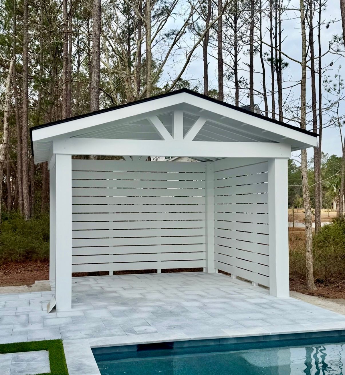Gable-roof poolside cabana with slat walls