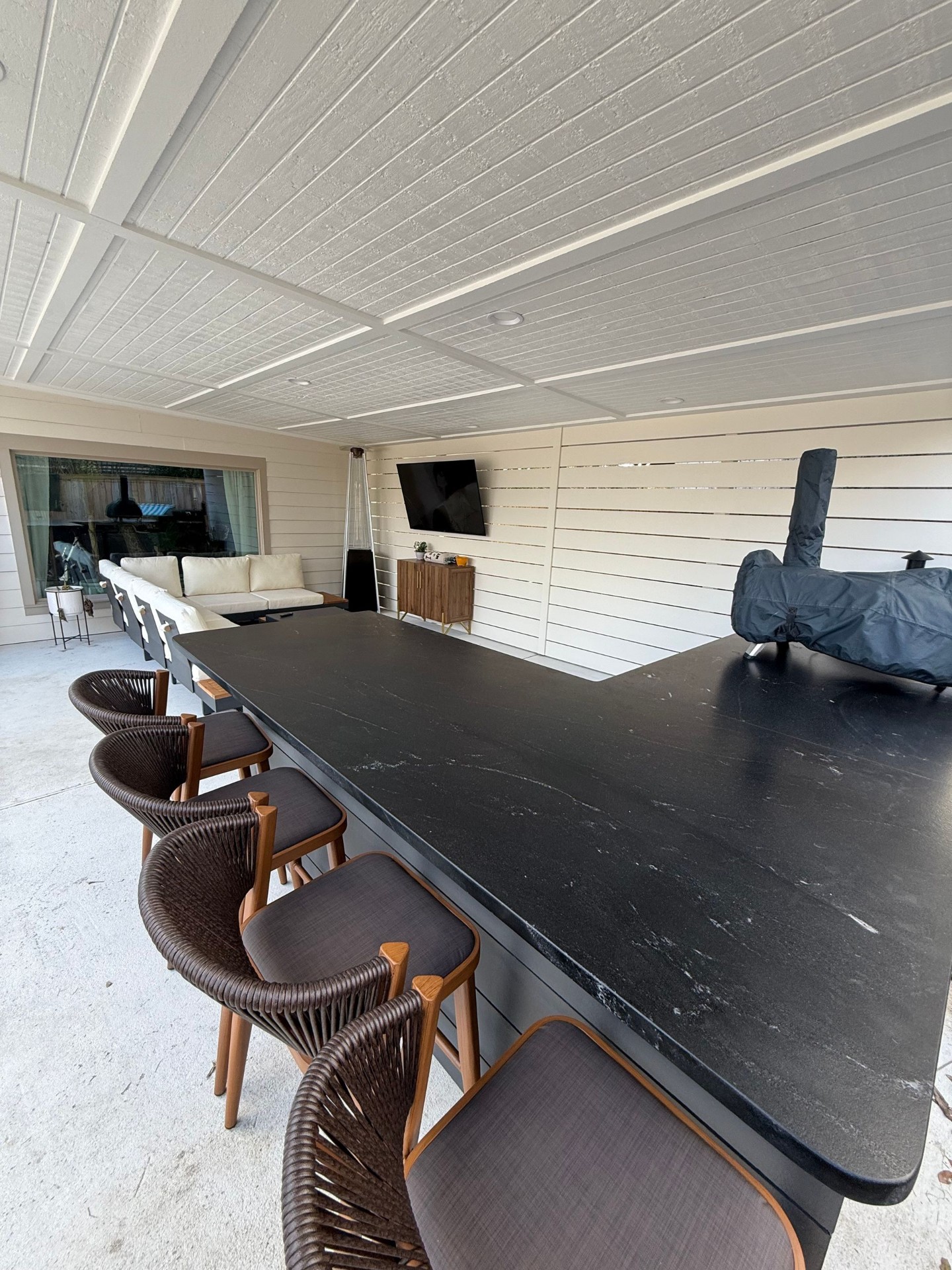 Covered bar lounge with seating and TV wall